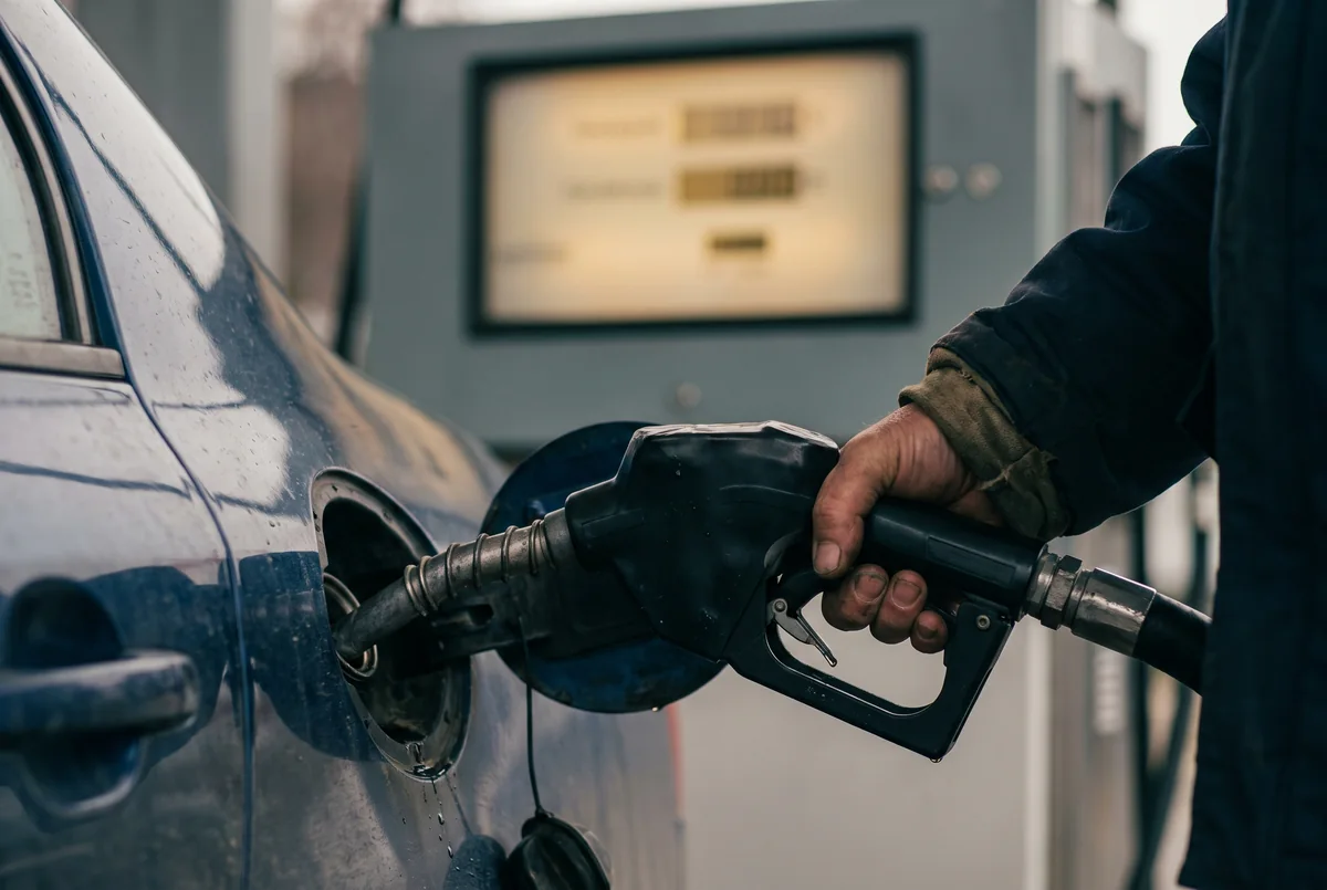 Close-up of a car being refuelled, dispenser display blurred